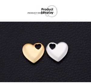 Macro shot of gold and silver heart pendants with mirror finish on black texture