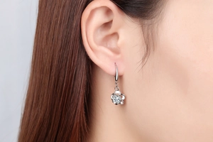 Close-up of silver plum blossom earrings with sparkling diamond studs on a model