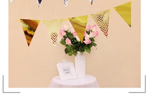 Detail of gold foil wave pattern pennant banner hanging above a party decoration table