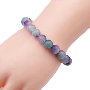 Detail of 10mm purple and green natural fluorite stone beads on a flexible bracelet