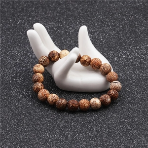 Detail shot of 10mm brown natural stone beaded bracelet on white hand display stand