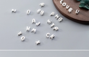Macro detail of S925 sterling silver hollow alphabet beads for DIY jewelry making