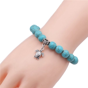 Detail shot of turquoise bead bracelet with silver sea turtle pendant on wrist