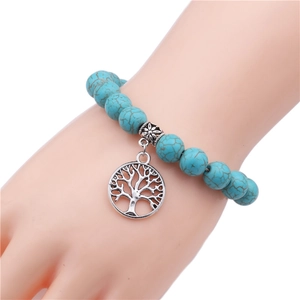 Detail of 10mm turquoise beaded bracelet featuring a tree of life metal charm and spacer