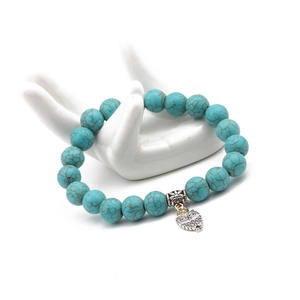 Detail of 10mm turquoise beaded bracelet with silver owl charm on hand model