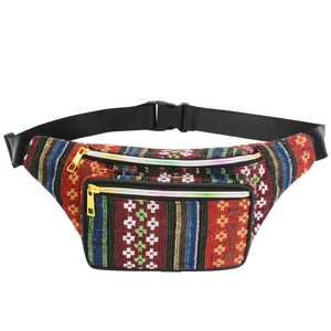 Detail of colorful woven bohemian waist bag featuring multi-stripe fabric and golden zippers