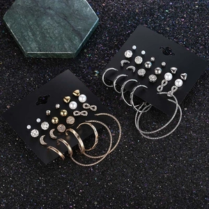 Detailed view of gold and silver earring sets with pearls and rhinestones on cards