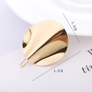 Detailed view of a 4.2cm golden wave-patterned circular metal hair clip on white card
