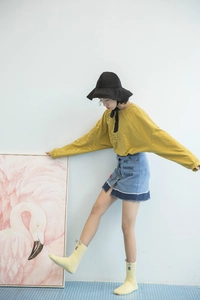 Detail of yellow striped top and denim skirt with AMT letters for a stylish girl outfit
