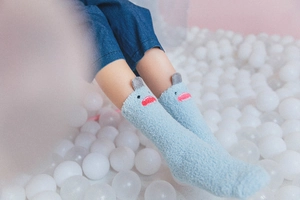 Detail of soft blue coral fleece crew socks featuring a cute cartoon shark design