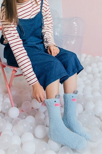 Detail of light blue coral fleece socks with cute 3D cartoon monster ears and embroidery