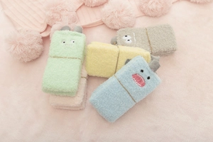 Close-up of colorful coral fleece monster socks in green, yellow, blue, beige, and grey