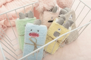 Detail of colorful fuzzy monster socks with paper labels in a white wire basket