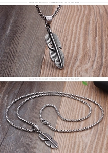 Macro shot of retro feather pendant with black oxidized finish and box chain detail