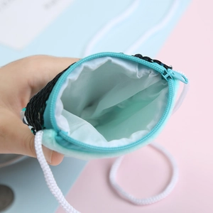 Detail of sequin coin purse with smooth blue lining and durable rope shoulder strap