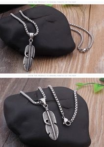 Macro detail of retro stainless steel feather pendant necklace with vintage oxidized finish