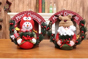 Detail of Christmas wreath with snowman and Santa figures on rustic wooden surface
