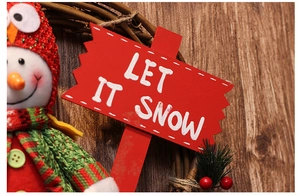 Detail of Let It Snow wooden sign with snowman on a rustic rattan Christmas wreath