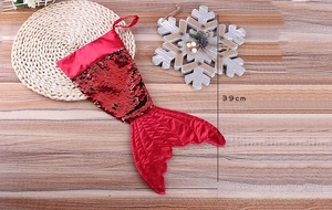 Detail of red mermaid tail Christmas stocking with reversible sequins on wooden background