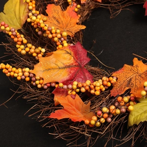 Ghirlanda autunnale con foglie di acero colorate e bacche su base di rattan naturale