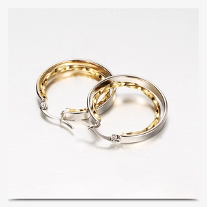 Close-up of 28mm dual-tone gold and silver layered hoop earrings with twisted metal texture