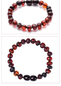 Macro view of dark red Baltic amber baby bracelet with irregular translucent beads