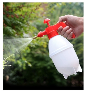 Action shot of garden pressure sprayer with brass nozzle spraying fine mist on plants