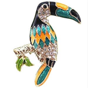 Detailed view of toucan brooch featuring colorful enamel and inlaid white crystals on gold