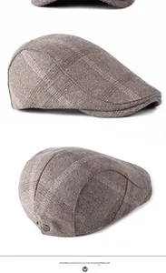 Détail de la casquette plate marron à carreaux avec texture tweed et boucle métal