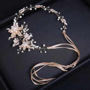Detail of bridal headband with gold floral metalwork, white pearls, and crystals on black