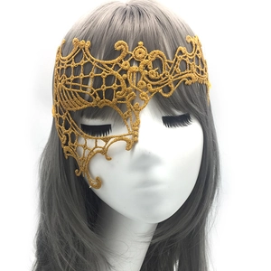 Detail of golden lace masquerade mask showing intricate phoenix pattern on a model