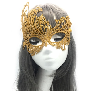 Macro view of gold lace masquerade mask with ornate feather patterns on a model