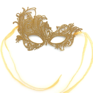 Close-up of golden lace masquerade mask with intricate hollow patterns and satin ribbons