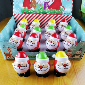 Macro shot of 16 wind-up Santa toys in a festive box and displayed on wood