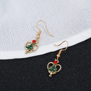 Close-up of Christmas tree heart earrings with red rhinestones and golden hooks