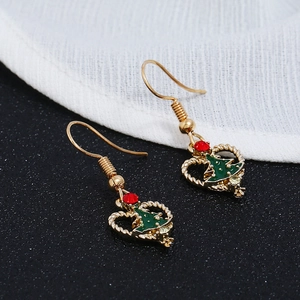 Detailed macro view of Christmas tree earrings with green enamel and red rhinestones