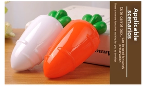Detail of carrot-shaped plastic candy boxes in orange and cream on a wooden table