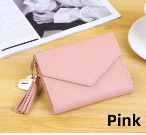 Pink faux leather envelope wallet detail featuring gold heart pendant and tassel