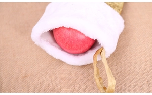 Detail of sequin mermaid Christmas stocking with plush cuff and red apple inside