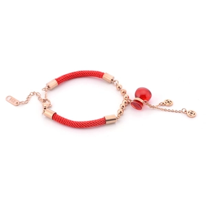 Dettaglio bracciale in corda rossa con monete in oro rosa e ciondolo rosso traslucido