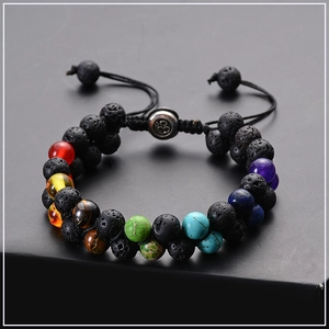 Macro shot of double-layer lava stone and seven chakra beads on a dark surface