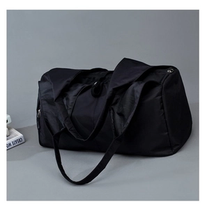 Detail of black waterproof nylon yoga travel bag with durable straps and polished texture