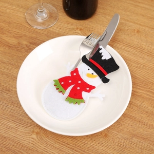 Detailed view of snowman cutlery holder with metal fork and knife on a white plate