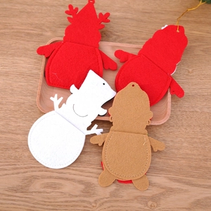 Close-up of felt Christmas cutlery holders in reindeer and snowman shapes on wood