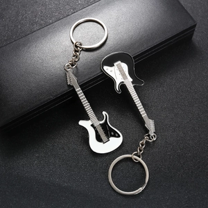 Guitar keychain pair in black and white enamel finish on professional dark display