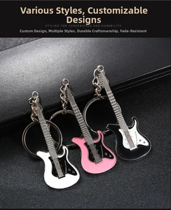 Three colorful electric guitar metal keychains in white, pink, and black on black leather