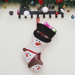 Plush Christmas stocking with 3D snowman motifs and gift boxes on festive wooden background