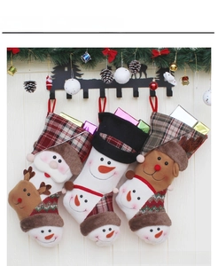 Three Christmas stockings with Santa, Snowman and Reindeer on a wall hook