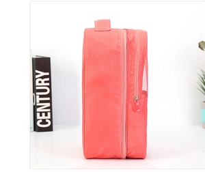 Detalle de bolsa para zapatos coral con capa de malla transpirable y asa de transporte