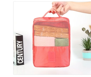 Detalle de la bolsa de viaje impermeable rojo coral con malla y asa de mano
